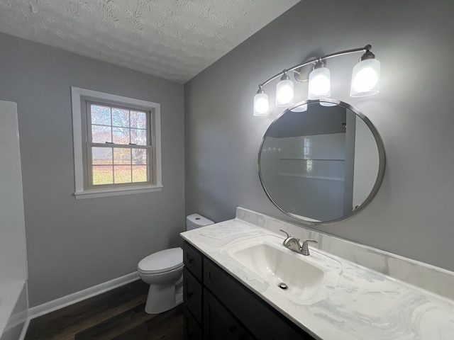 bathroom with hardwood / wood-style floors, vanity, a textured ceiling, and toilet