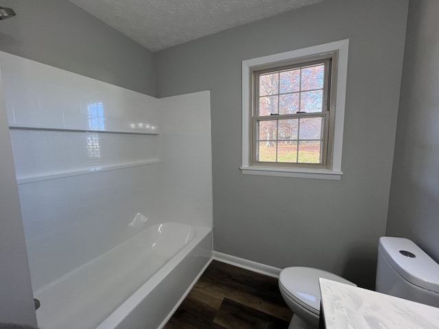 full bathroom featuring vanity, hardwood / wood-style floors, a textured ceiling, and toilet