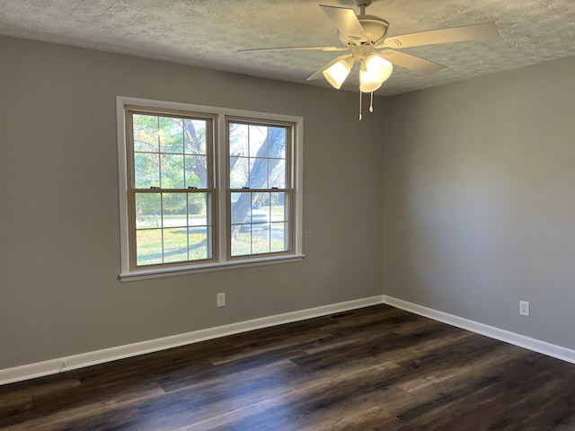 empty room with ceiling fan, dark hardwood / wood-style flooring, and a textured ceiling