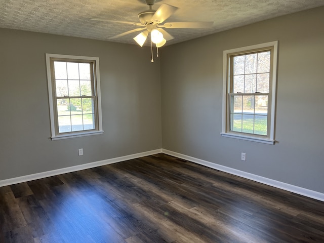 empty room with ceiling fan, dark hardwood / wood-style flooring, and a textured ceiling