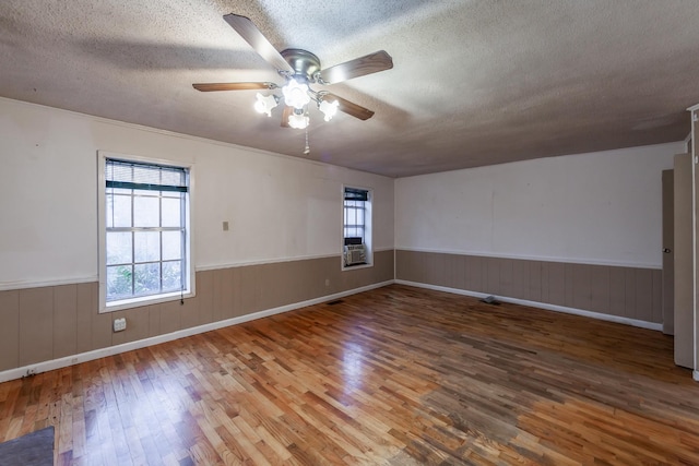 empty room featuring ceiling fan, a textured ceiling, and hardwood / wood-style flooring