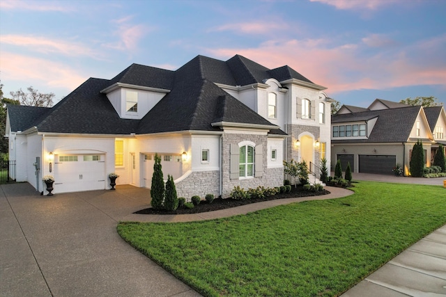 french country style house featuring a yard and a garage