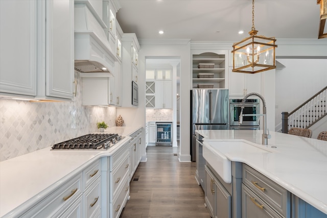 kitchen with hanging light fixtures, stainless steel appliances, tasteful backsplash, premium range hood, and crown molding