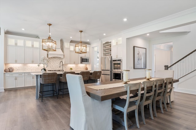 dining room with hardwood / wood-style flooring and crown molding