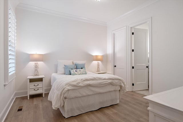 bedroom featuring light hardwood / wood-style flooring and ornamental molding