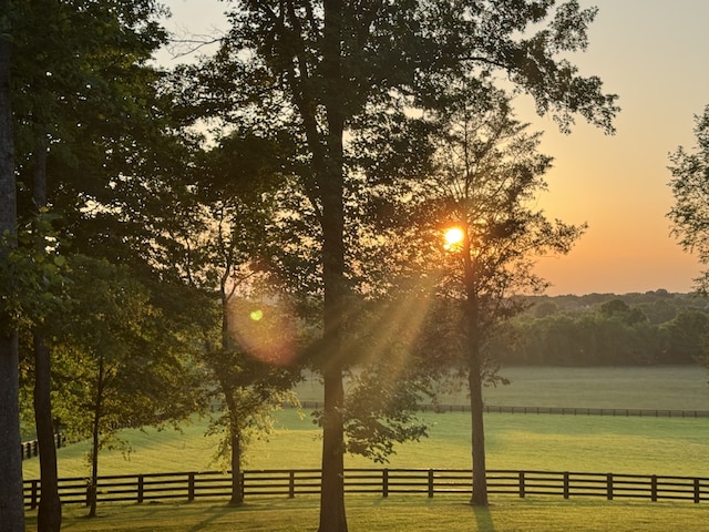 view of home's community featuring a rural view, a yard, and a water view