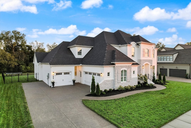 french country style house featuring a front yard and a garage