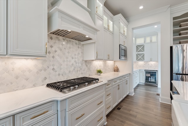 kitchen featuring premium range hood, wine cooler, dark hardwood / wood-style floors, appliances with stainless steel finishes, and white cabinetry