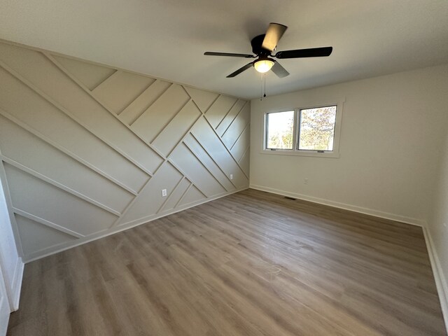 unfurnished room with ceiling fan and hardwood / wood-style flooring