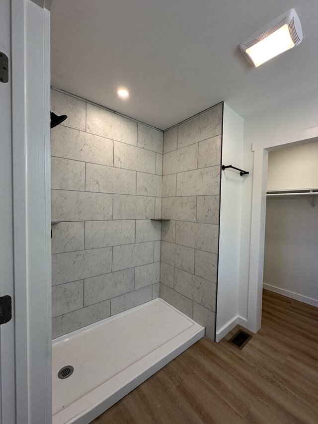 bathroom featuring wood-type flooring and tiled shower