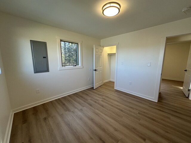 unfurnished bedroom featuring hardwood / wood-style flooring and electric panel