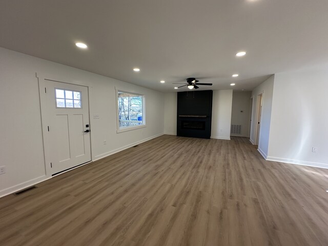 unfurnished living room featuring ceiling fan and light hardwood / wood-style flooring