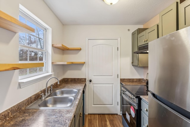 kitchen featuring dark wood-type flooring, sink, green cabinetry, a textured ceiling, and stainless steel appliances