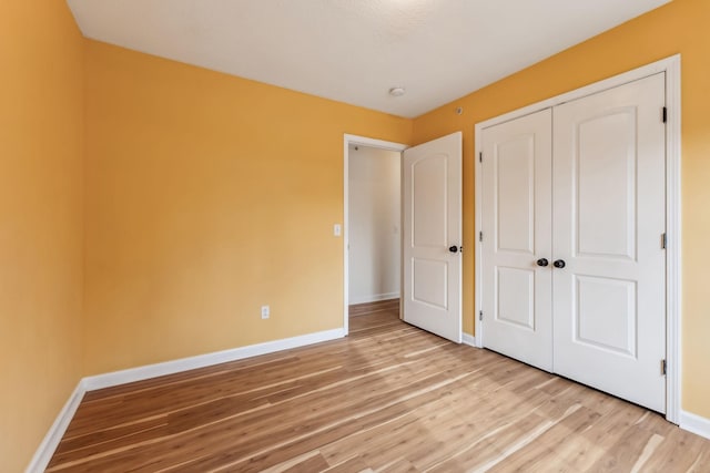 unfurnished bedroom with light hardwood / wood-style floors and a closet