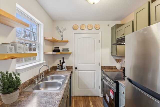 kitchen featuring appliances with stainless steel finishes, dark hardwood / wood-style flooring, a textured ceiling, sink, and green cabinets