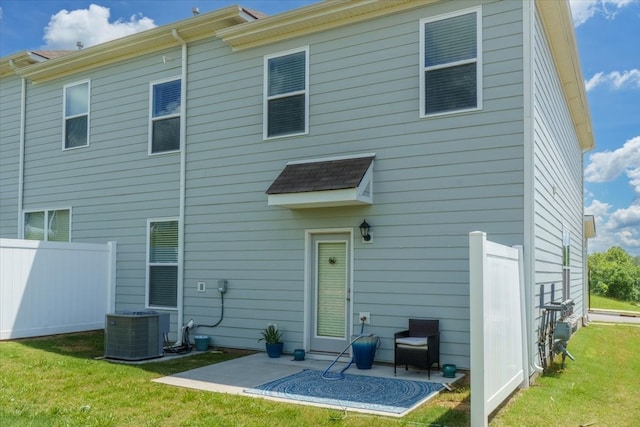 back of house with central AC, a yard, and a patio