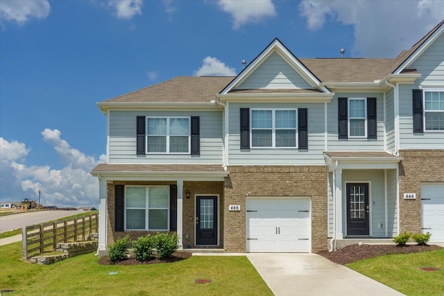 view of property with a garage and a front lawn