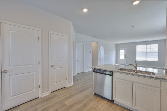 kitchen with white cabinets, sink, stainless steel dishwasher, light stone countertops, and light wood-type flooring