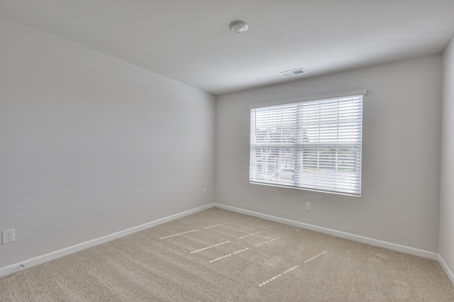 spare room featuring light carpet