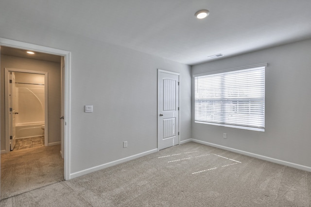 unfurnished bedroom with light colored carpet and a closet