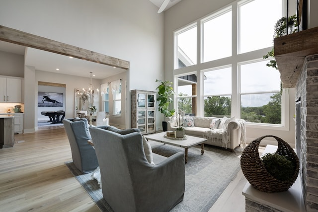 living room featuring plenty of natural light, light hardwood / wood-style floors, and a high ceiling