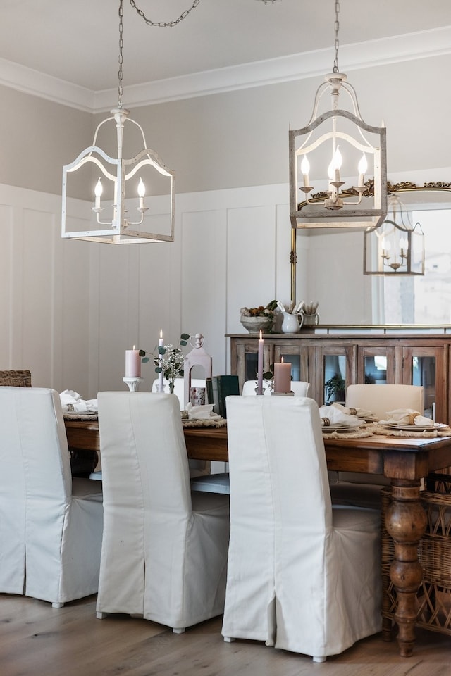 dining room featuring wood-type flooring, crown molding, and an inviting chandelier