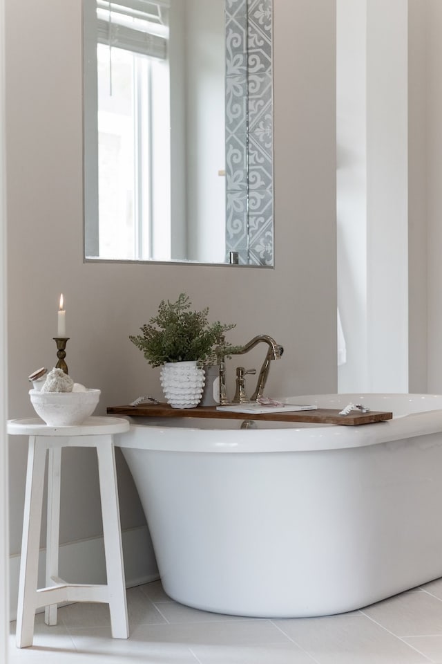 bathroom featuring a washtub, tile patterned floors, and sink