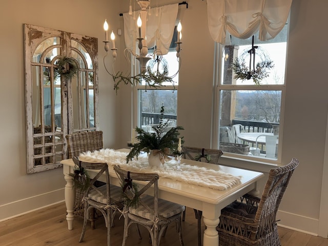 dining space with wood-type flooring and a chandelier