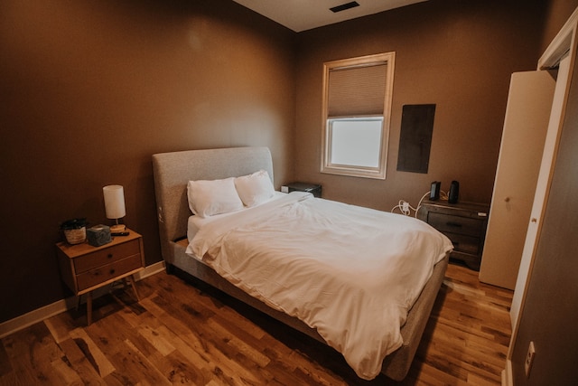 bedroom with dark wood-type flooring