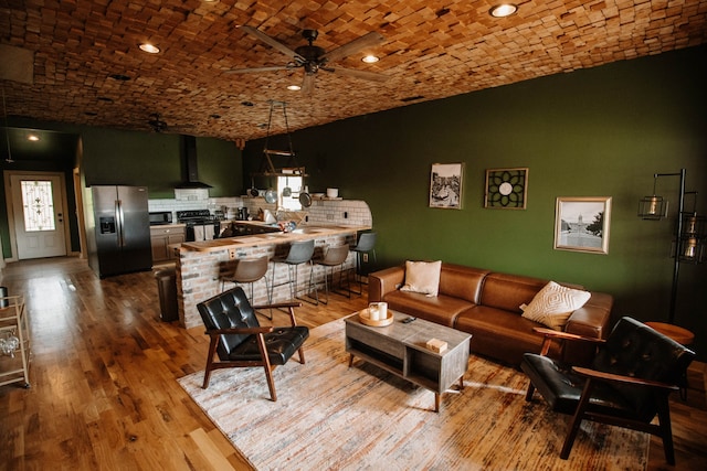 living room with brick ceiling, ceiling fan, and wood-type flooring