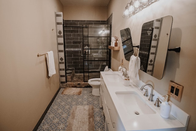 bathroom with tile patterned floors, vanity, toilet, and a shower with door