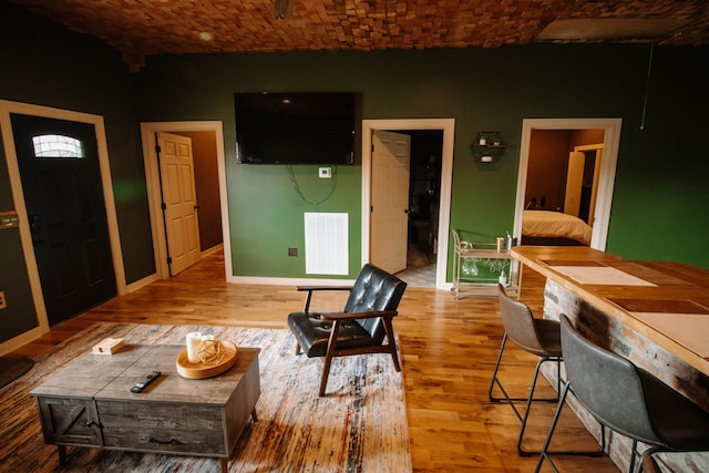 living room featuring light hardwood / wood-style flooring and brick ceiling