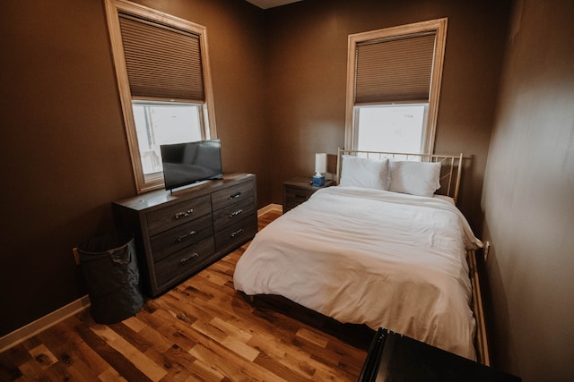 bedroom featuring multiple windows and light hardwood / wood-style flooring