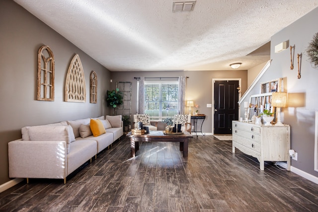 living room featuring a textured ceiling and dark hardwood / wood-style floors