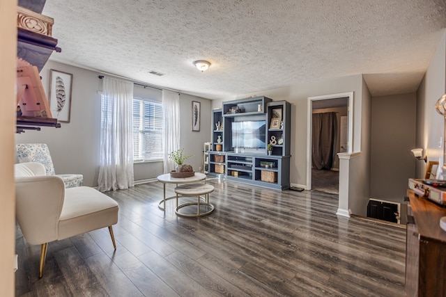 living room featuring a textured ceiling and dark wood-type flooring