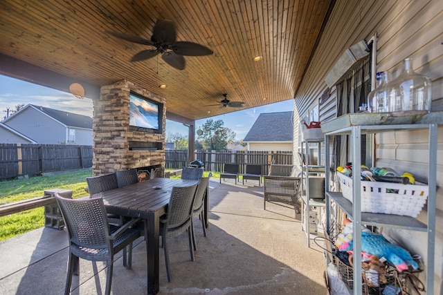 view of patio featuring an outdoor stone fireplace and ceiling fan