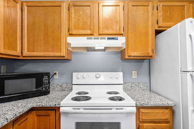 kitchen with light stone countertops and white appliances