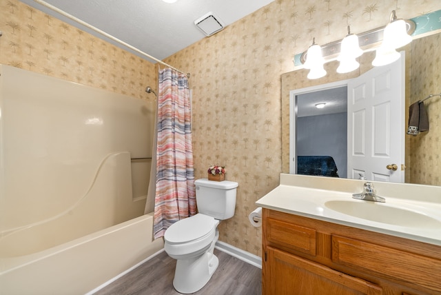 full bathroom with vanity, hardwood / wood-style flooring, toilet, a textured ceiling, and shower / tub combo