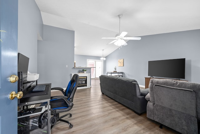 home office with ceiling fan, vaulted ceiling, and light hardwood / wood-style flooring