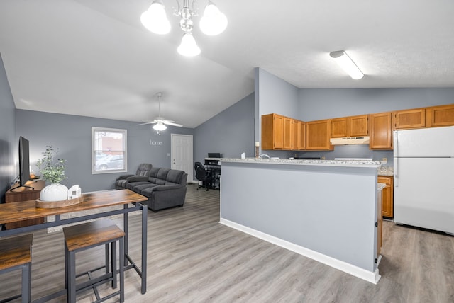 kitchen featuring light wood-type flooring, vaulted ceiling, and white refrigerator