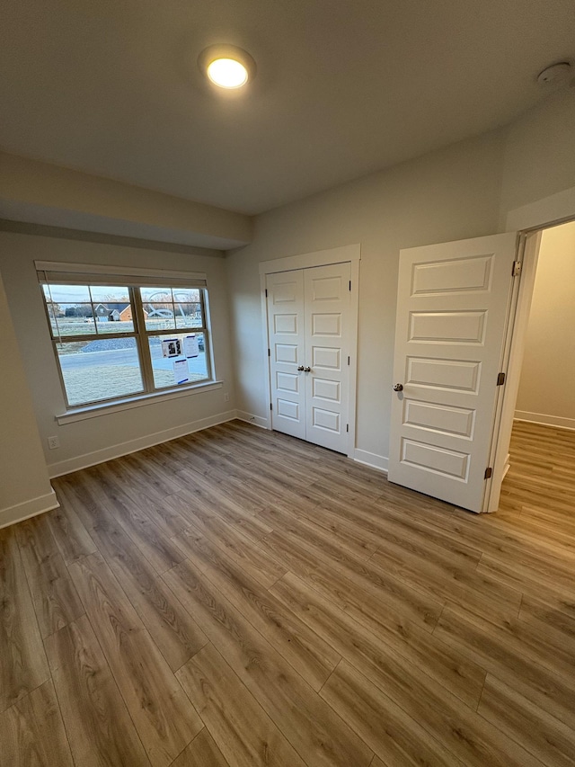 unfurnished bedroom with light hardwood / wood-style floors and a closet