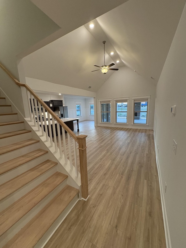 unfurnished living room with vaulted ceiling, light hardwood / wood-style flooring, and ceiling fan