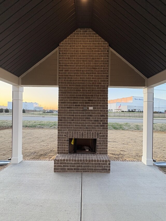 patio terrace at dusk with an outdoor brick fireplace