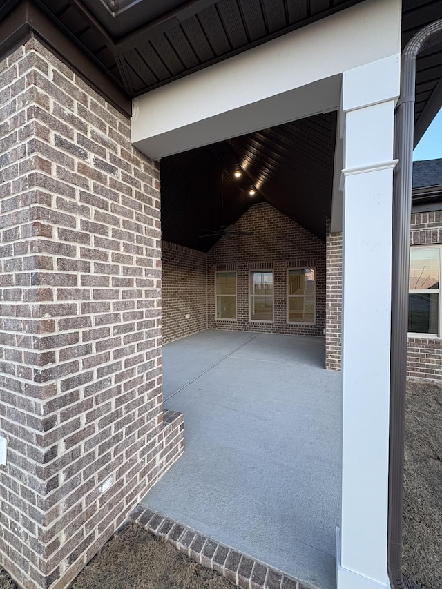 exterior space with lofted ceiling and brick wall