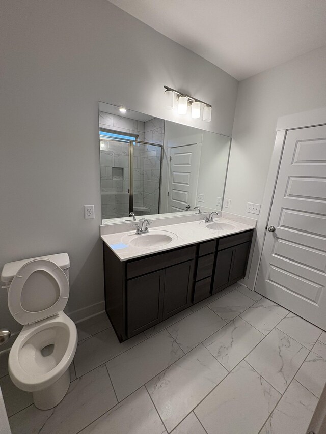 bathroom with vanity, toilet, and a shower with shower door