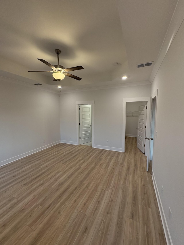 unfurnished room with light wood-type flooring, ceiling fan, and crown molding