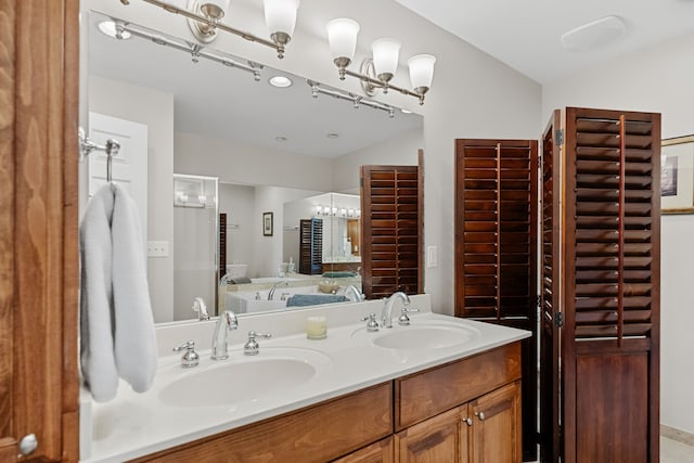 bathroom with a bath, vanity, and vaulted ceiling