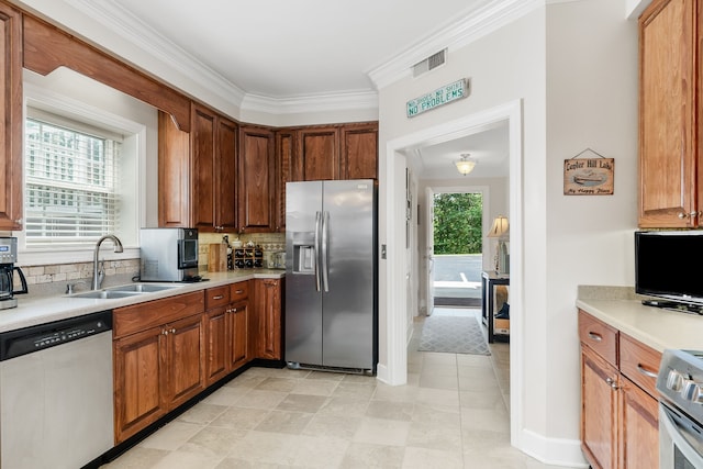 kitchen with decorative backsplash, a wealth of natural light, sink, and appliances with stainless steel finishes