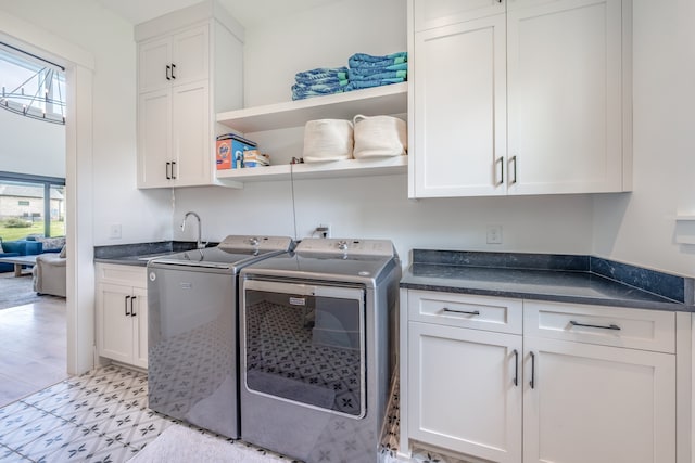 laundry room featuring cabinets, washing machine and dryer, a wealth of natural light, and sink