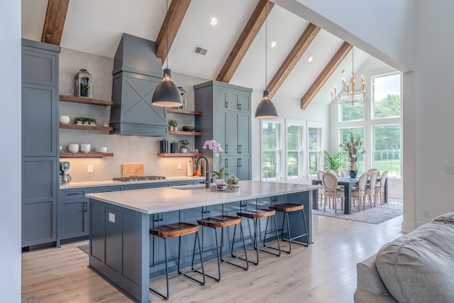 kitchen with decorative backsplash, light hardwood / wood-style flooring, high vaulted ceiling, and beamed ceiling